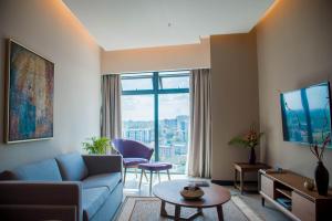a living room with a blue couch and a large window at Prime Living Luxury Apartments in Nairobi