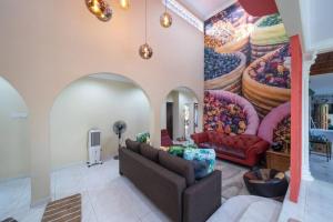 uma sala de estar com uma grande pintura na parede em Villa 23 - 4B/4B/PrivatePool/BBQ em Petaling Jaya
