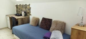a bedroom with a blue bed and a chair at Apartmán Mariposa 1 