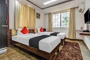 a hotel room with two beds and a window at Collection O 73565 J J Global Exotics Stays in Bangalore