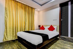 a bedroom with a large bed with red pillows at Collection O 73565 J J Global Exotics Stays in Bangalore
