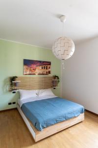 um quarto com uma cama grande e uma luz pendente em Residenza al Corso em Verona