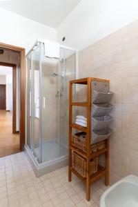 uma casa de banho com chuveiro e uma prateleira com toalhas em Residenza al Corso em Verona