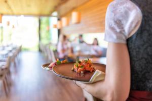 a woman holding a plate of food in a restaurant at Landgut am Pößnitzberg in Leutschach