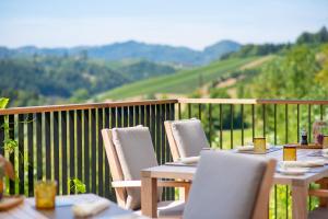 a table and chairs on a balcony with a view at Landgut am Pößnitzberg in Leutschach