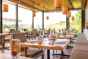 a restaurant with wooden tables and chairs and windows at Landgut am Pößnitzberg in Leutschach
