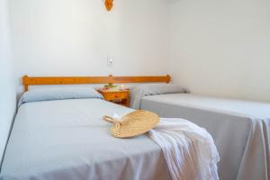 a straw hat sitting on two beds in a room at Apartamentos Sa Caleta in Sa Caleta +40 photos