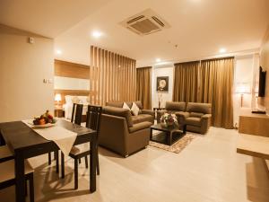 a living room with a table and a dining room at Garden Sentral Hotel in Kuala Belait