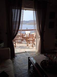 a room with a door open to a patio with a table at Calma in Perdika