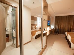 a hotel room with two beds and a glass wall at Garden Sentral Hotel in Kuala Belait