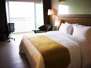 a hotel room with a large bed and a window at Garden Sentral Hotel in Kuala Belait