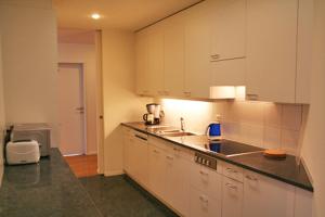 uma cozinha com armários brancos e uma bancada em Nest - Baarerstrasse 55 em Zug
