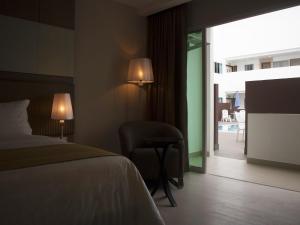 a hotel room with a bed and a chair and a window at Garden Sentral Hotel in Kuala Belait