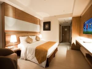 a hotel room with a bed and a couch at Garden Sentral Hotel in Kuala Belait