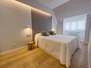 a bedroom with a large white bed with a window at Hi! Burgos - SIDI - VUT-472 - Exclusivo apartamento moderno en el corazón de la ciudad in Burgos