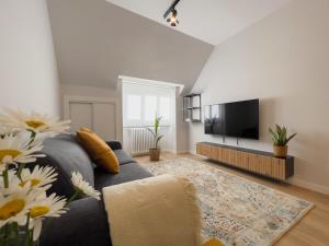 a living room with a blue couch and a flat screen tv at Hi! Burgos - SIDI - VUT-472 - Exclusivo apartamento moderno en el corazón de la ciudad in Burgos