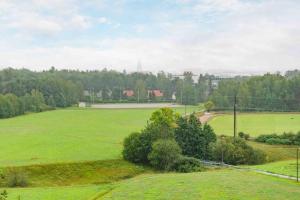 a large green field with trees in the background at Saris 4 bedroom apartment with view in Turku