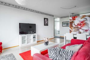 a living room with a red couch and a tv at Saris 4 bedroom apartment with view in Turku