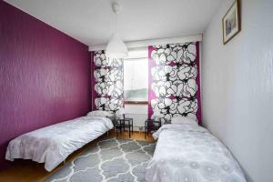two beds in a room with purple walls and a window at Saris 4 bedroom apartment with view in Turku