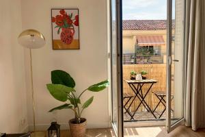 Habitación con planta y balcón con mesa. en Central and blight flat with balconies, en Marsella
