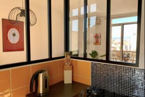 cocina con azulejos negros y naranjas y fregadero en Central and blight flat with balconies, en Marsella