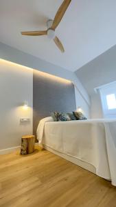 a bedroom with a bed with a ceiling fan at Hi! Burgos - SIDI - VUT-472 - Exclusivo apartamento moderno en el corazón de la ciudad in Burgos