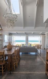 a dining room with a table and chairs and a chandelier at Driftwood in Paternoster