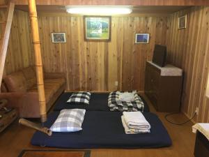 a room with two beds and a couch in a cabin at 【1日1組限定】長野県・安曇野の一軒家貸切宿 「うまや UMAYA」 in Matsukawa
