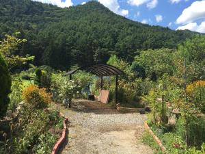 a garden with a gazebo in the middle of a mountain at 【1日1組限定】長野県・安曇野の一軒家貸切宿 「うまや UMAYA」 in Matsukawa