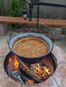 Ein Topf Suppe hängt über einem Feuer in der Unterkunft Váradi Vendégház in Doboz