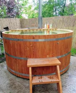 a wooden barrel with a bench and a hot tub at Váradi Vendégház in Doboz