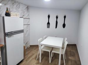 a kitchen with a white table and a white refrigerator at Rua da Avó 