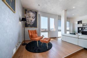a living room with a chair and a couch at [Via Indipendenza] – Attico di lusso con Piscina in Bologna
