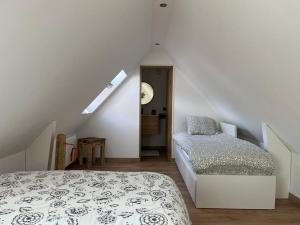 a attic room with a bed and a chair at La Masure - Jacuzzi privatif - La mer à deux pas in Cayeux-sur-Mer