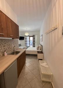 a kitchen with a sink and a living room at Alkyonari By Maria in Ammouliani