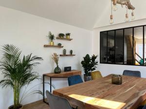 - une salle à manger avec une table et des chaises en bois dans l'établissement La Masure - Jacuzzi privatif - La mer à deux pas, à Cayeux-sur-Mer