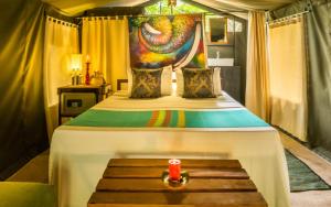 um quarto com uma cama grande e um banco. em Mahoora - Yala by Eco Team em Yala