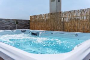 uma banheira de hidromassagem com água em frente a uma cerca em [Via Indipendenza] – Attico di lusso con Piscina em Bolonha