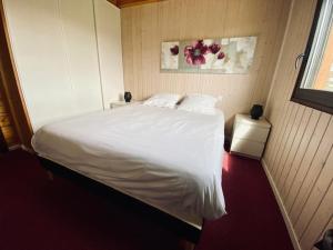 ein Schlafzimmer mit einem weißen Bett und einem Fenster in der Unterkunft Chalet indépendant 2000m2 de terrain 3 chambres 
