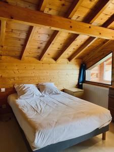 Bett in einem Zimmer mit Holzdecke in der Unterkunft Chalet indépendant 2000m2 de terrain 3 chambres 