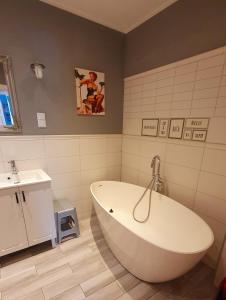 y baño con bañera blanca y lavamanos. en Apartament Berg en Szczawno-Zdrój