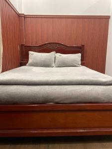 a bed with a wooden headboard with two pillows at Phụng Kim Thảo Hotel Long An in Long An