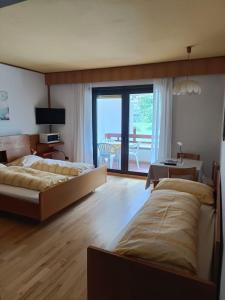 1 dormitorio con 2 camas, mesa y balcón en Residence Gerold, en Rablà