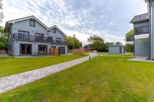 a large white house with a lawn in front of it at Lodge54 in Sankt Peter-Ording