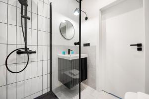 a bathroom with a shower with a sink and a mirror at Uniwersytet Warszawski Modern Apartment in Warsaw