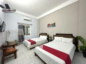 a hotel room with two beds and a tv at OYO 1187 Suoi Da Motel in Da Nang