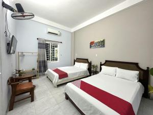 a hotel room with two beds and a television at OYO 1187 Suoi Da Motel in Da Nang