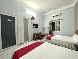 a bedroom with two beds and a sliding glass door at OYO 1187 Suoi Da Motel in Da Nang