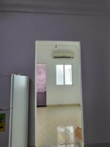um quarto branco com um frigorífico e uma janela em Appartement Tanger 3 em Tânger