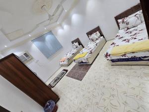 a large room with two beds and a tv at شقة مفروشة في المدينة المنورة- رانونا1 in ‘Urwah